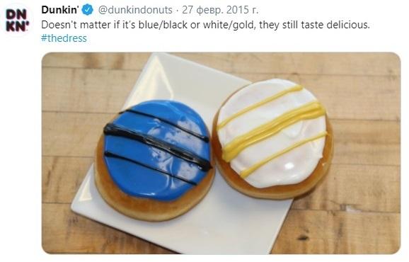 Two donuts inspired by the viral dress illusion, one decorated with blue and black icing, the other with white and gold icing, placed on a white square plate.