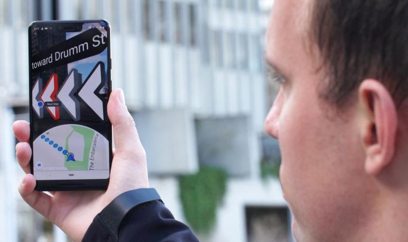 Person using a smartphone with augmented reality navigation to guide them toward Drumm St.