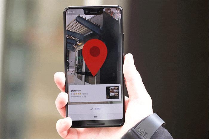 Person holding a smartphone with augmented reality navigation displaying directions to a Starbucks location.